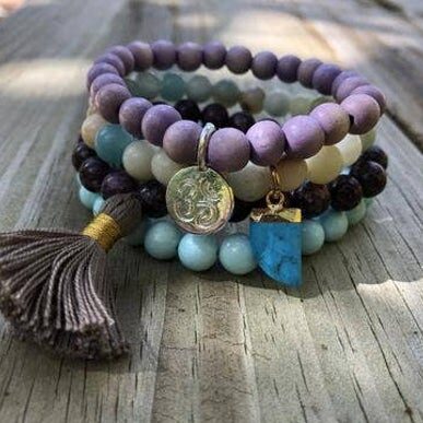 A perfect pairing of colors and beads make for the perfect combo day or night. 

Purple dyed wooden beads add a pop of color. 

Known as the 'hope stone' the Amazonite inspires confidence and self assurance. 

Lepidolite added for harmony and concentration. 

Matte Turquoise Blue 
Om Charm

Handmade Tassel

The Howlite blue charm reduces anxiety and works overtime to calm the energy around you.

Made in the USA. 🇺🇸